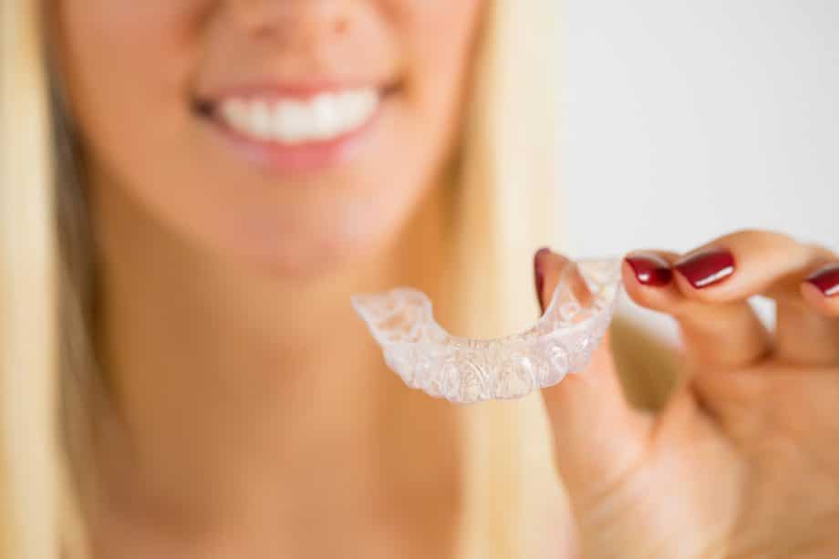 woman holding an invisalign retainer
