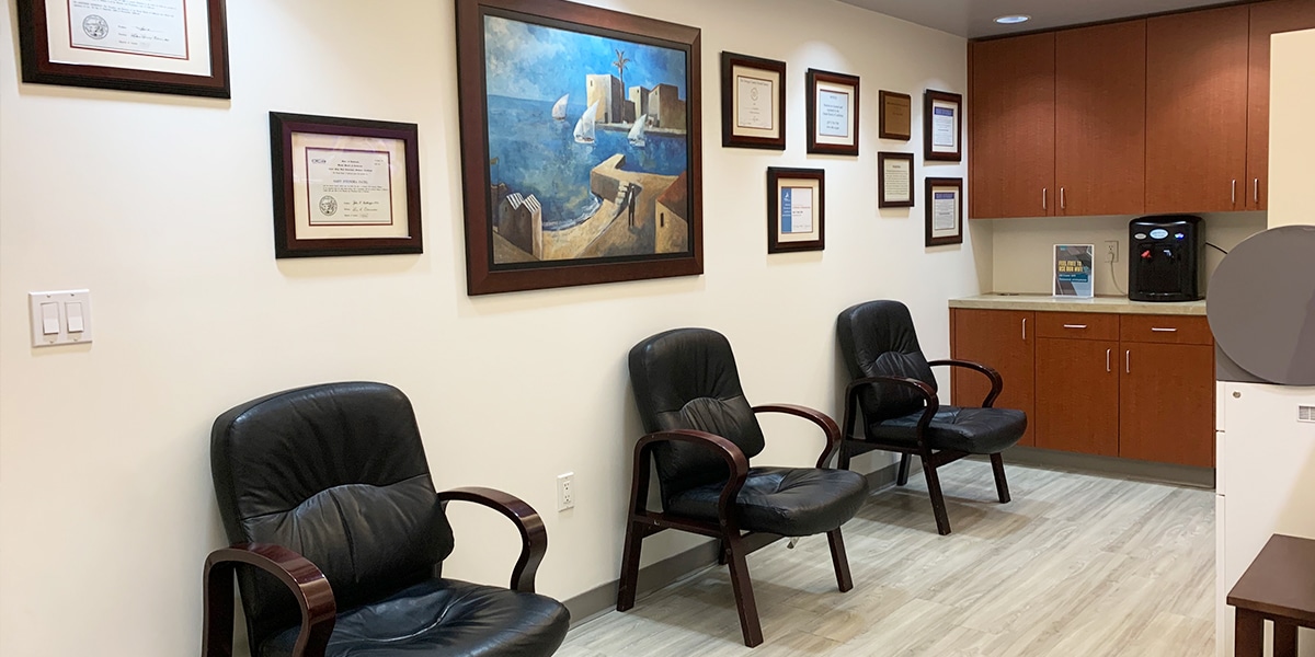 waiting area in dental office with licenses in frames on the wall